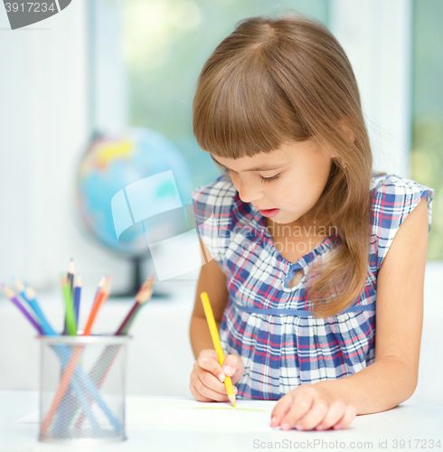 Image of Little girl is drawing using pencils