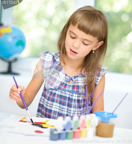 Image of Little girl is painting with gouache