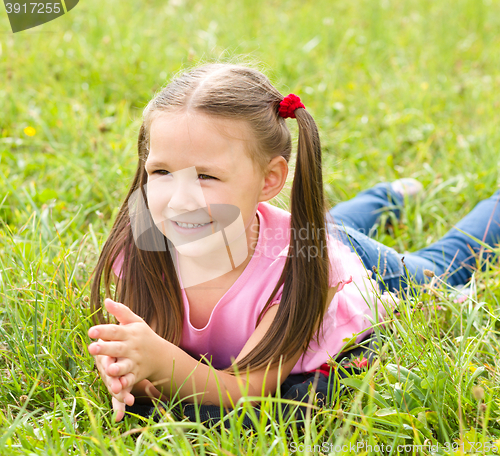 Image of Portrait of a little girl laying on green grass