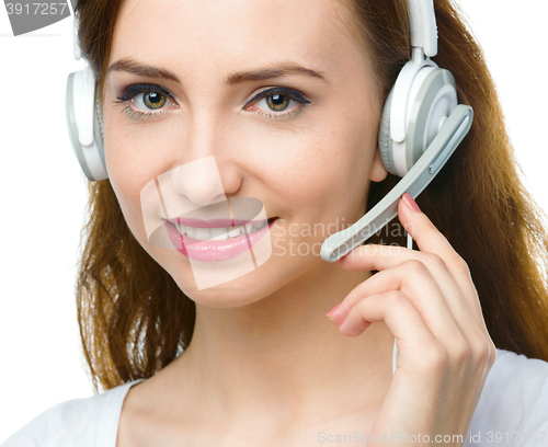 Image of Lovely young woman is talking to customers