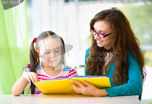 Image of Mother is reading book with her daughter