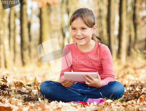 Image of Little girl is reading from tablet