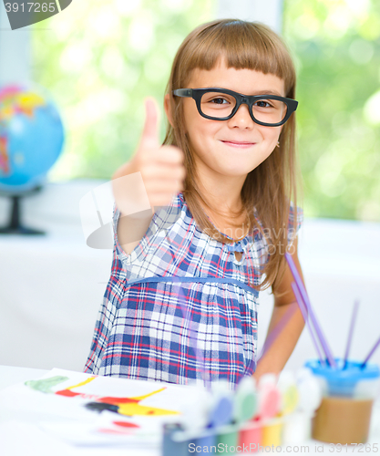 Image of Little girl is painting with gouache