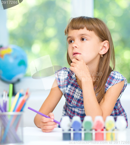 Image of Little girl is painting with gouache