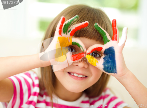 Image of Portrait of a cute girl playing with paints