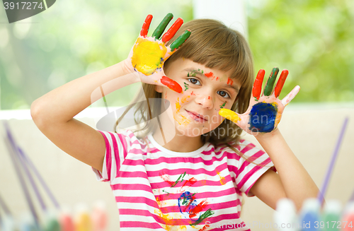 Image of Portrait of a cute girl playing with paints