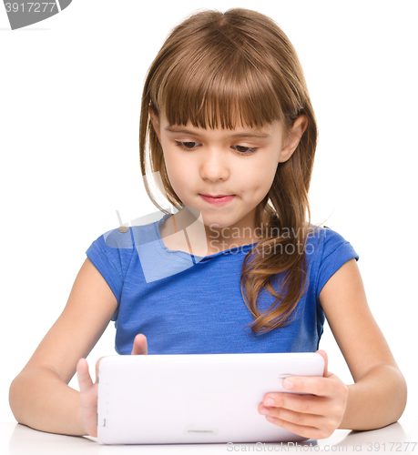 Image of Young girl is using tablet while studying