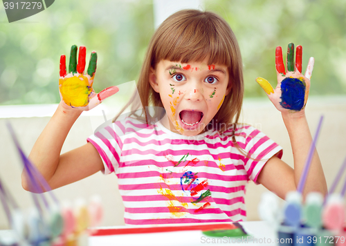 Image of Portrait of a cute girl playing with paints