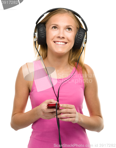 Image of Teen girl enjoying music using headphones