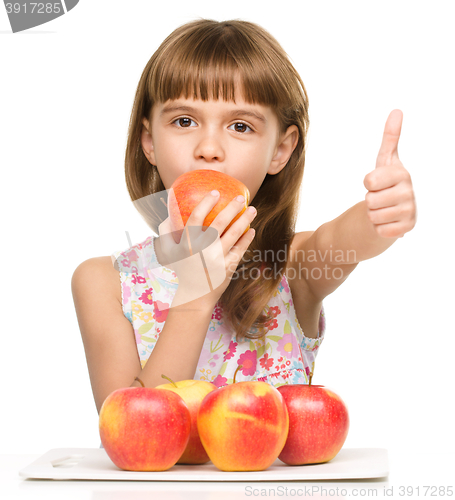 Image of Little girl with apples is showing thumb up sign