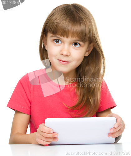 Image of Young cheerful girl is using tablet