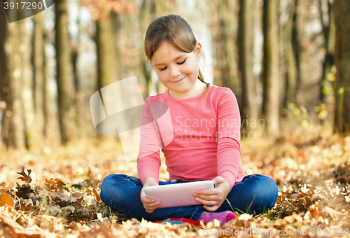 Image of Little girl is reading from tablet