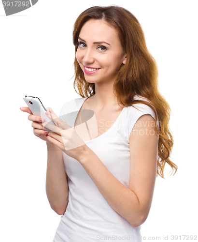 Image of Young woman is typing sms message on her phone