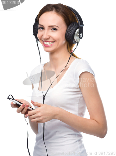 Image of Young woman enjoying music using headphones