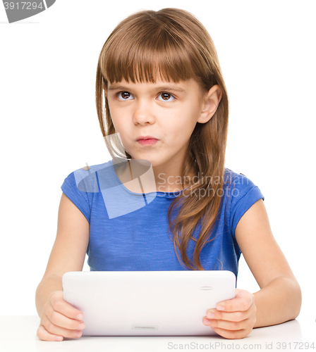 Image of Young girl is using tablet while studying