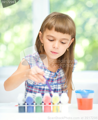 Image of Little girl is painting with gouache