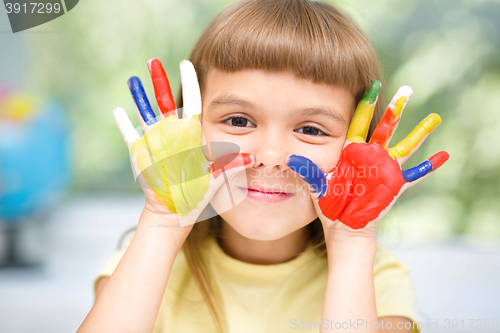 Image of Portrait of a cute girl playing with paints