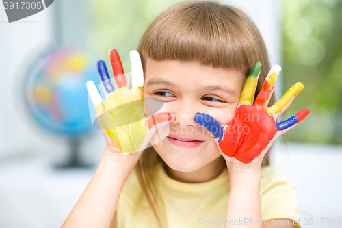 Image of Portrait of a cute girl playing with paints