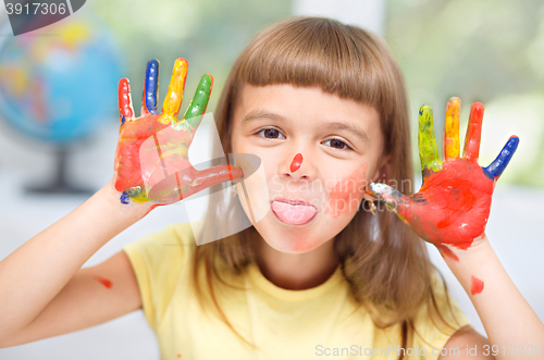 Image of Portrait of a cute girl playing with paints