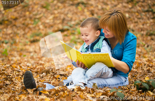 Image of Mother is reading book with her son