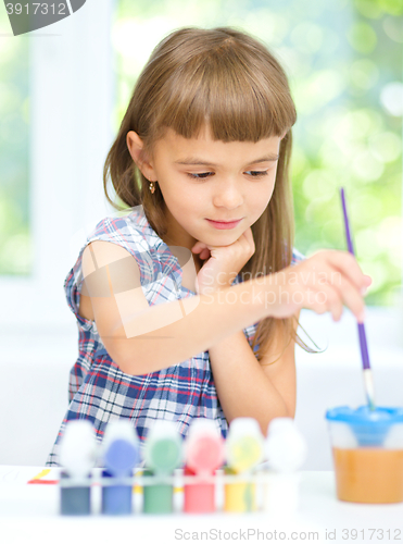 Image of Little girl is painting with gouache