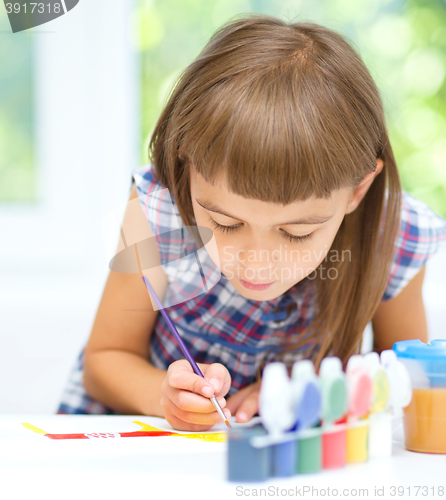 Image of Little girl is painting with gouache