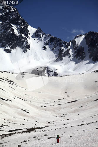 Image of Hiker in snowy mountains at nice spring day