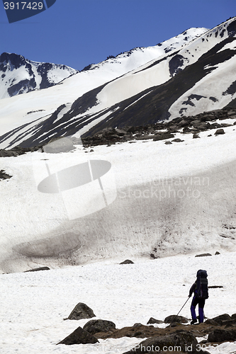 Image of Hiker in snowy mountains at spring