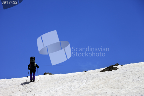 Image of Hiker in snowy mountains at spring
