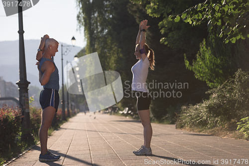 Image of couple warming up and stretching before jogging