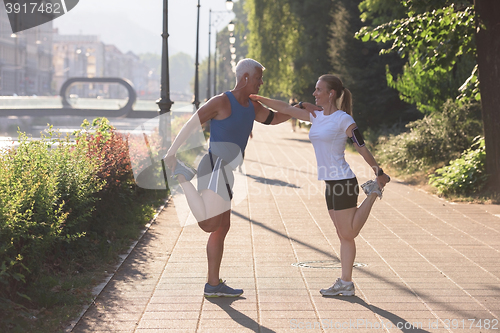 Image of couple warming up and stretching before jogging