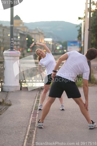 Image of couple warming up before jogging