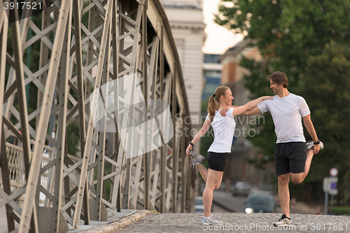 Image of couple warming up and stretching before jogging