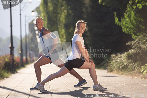 Image of couple warming up and stretching before jogging