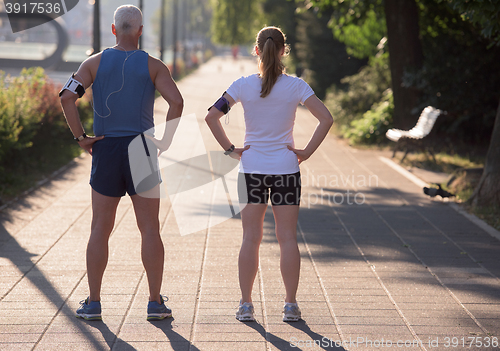 Image of jogging couple planning running route  and setting music