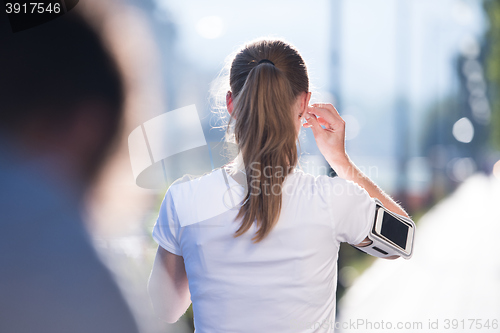 Image of jogging woman setting phone before jogging