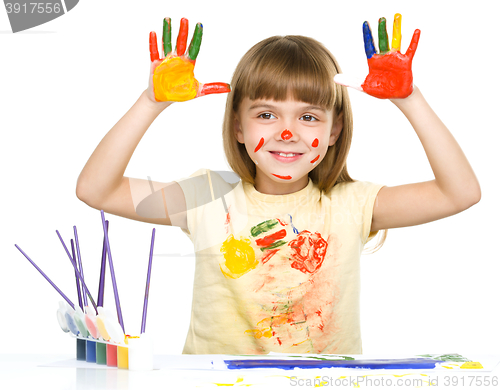 Image of Portrait of a cute girl playing with paints