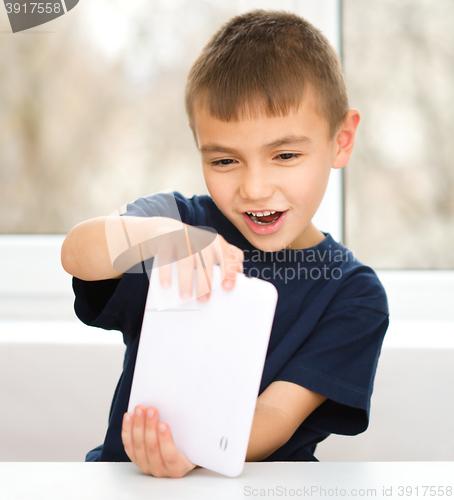 Image of Young boy is using tablet