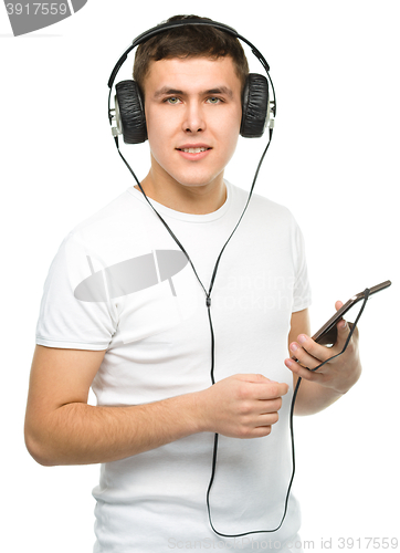 Image of Young man enjoying music using headphones