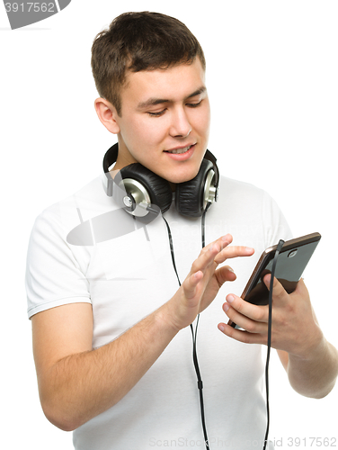 Image of Young man enjoying music using headphones