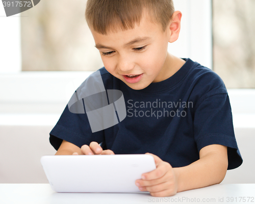 Image of Young boy is using tablet