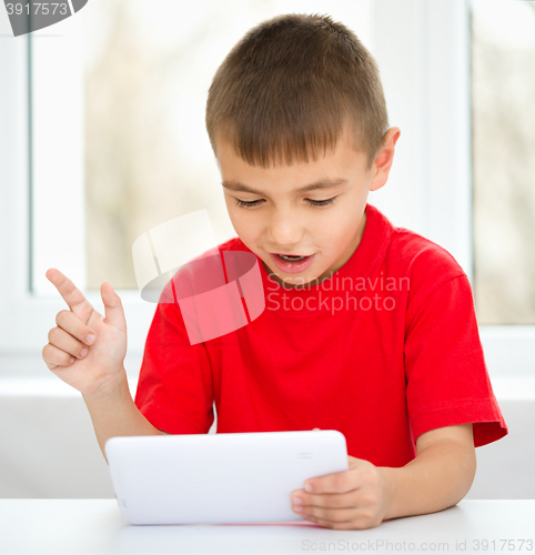 Image of Young boy is using tablet