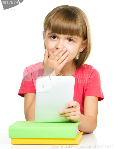 Image of Young girl is using tablet while studying