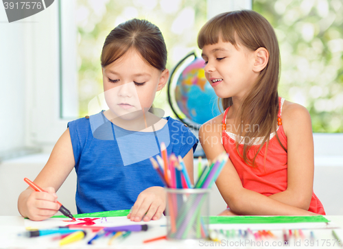 Image of Little girls are drawing using pencils