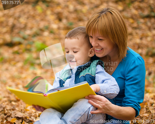 Image of Mother is reading book with her son