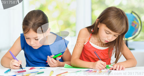 Image of Little girls are drawing using pencils