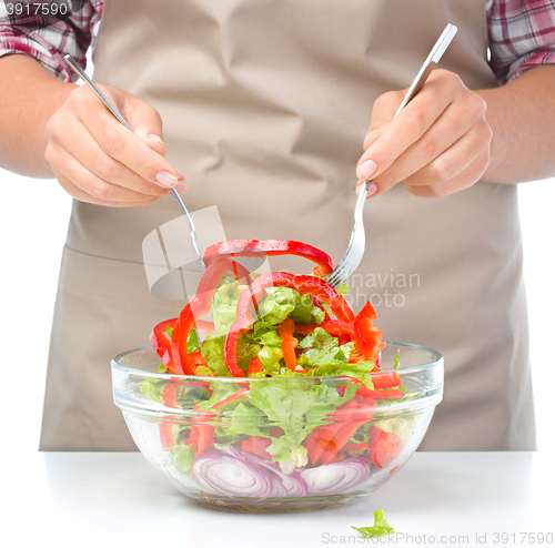 Image of Cook is mixing salad