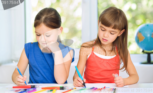 Image of Little girls are drawing using pencils