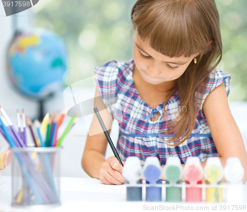 Image of Little girl is painting with gouache