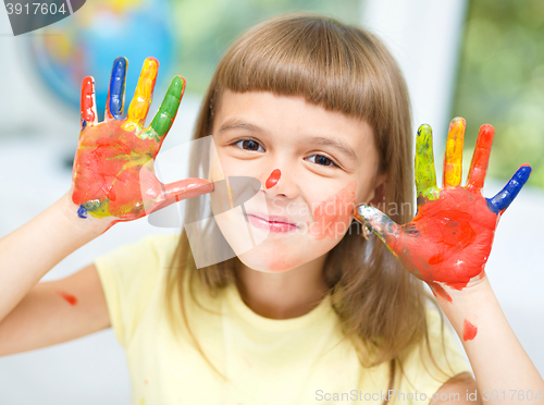 Image of Portrait of a cute girl playing with paints